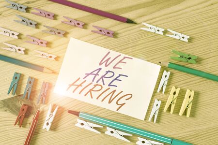 Handwriting text We Are Hiring. Conceptual photo Workforce Wanted HR recruiting new hire employee Vacancy Colored clothespin papers empty reminder wooden floor background officeの写真素材