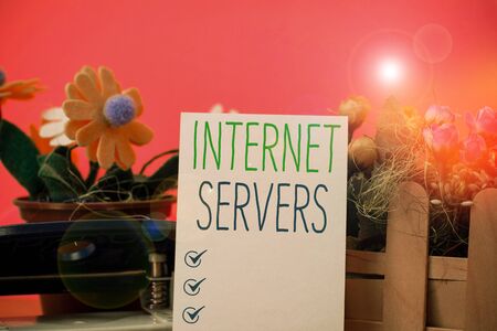Writing note showing Internet Servers. Business concept for delivers the content of the page back to the user Flowers and writing equipments plus plain sheet above textured backdropの写真素材