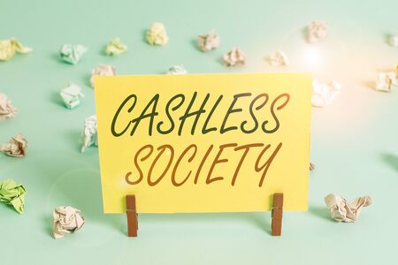 Text sign showing Cashless Society. Business photo text financial transactions are executed in electronic format Colored crumpled rectangle shaped reminder paper light blue backgroundの写真素材