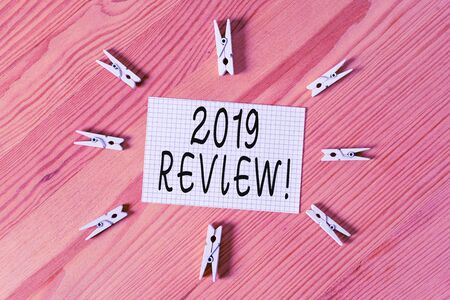 Conceptual hand writing showing 2019 Review. Concept meaning remembering past year events main actions or good shows Colored crumpled papers wooden floor background clothespinの写真素材