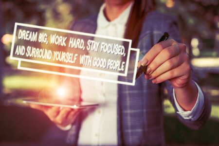 Text sign showing Dream Big Work Hard Stay Focused. Business photo showcasing Dream Big Work Hard Stay Focused And Surround Yourself With Good People Outdoor background with business woman holding lap top and penの写真素材