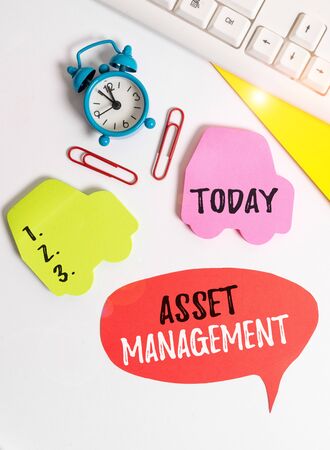 Writing note showing Asset Management. Business concept for analysisaged investment of assets of a demonstrating or business Flat lay with copy space on bubble paper clock and paper clipsの写真素材
