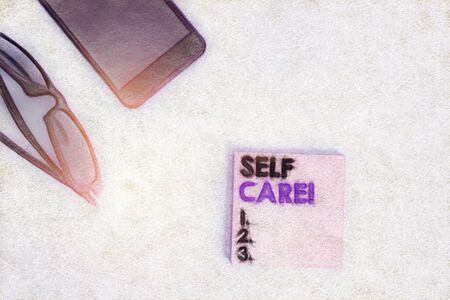 Text sign showing Self Care. Business photo showcasing the practice of taking action to improve one s is own health Dark eyeglasses colored sticky note smartphone fashion pastel backgroundの写真素材