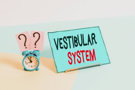 Writing note showing Vestibular System. Business concept for provides the leading contribution to the sense of balance Alarm clock beside a Paper sheet placed on pastel backdropの写真素材