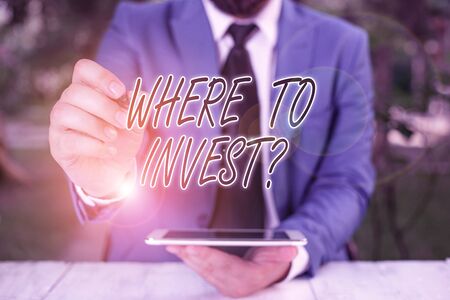 Word writing text Where To Invest Question. Business photo showcasing asking about where put money into financial schemes or shares Businessman pointing with pen in empty copy spaceの写真素材