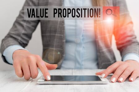 Conceptual hand writing showing Value Proposition. Concept meaning innovation service intended make product attractive Business woman sitting with mobile phone on the tableの写真素材