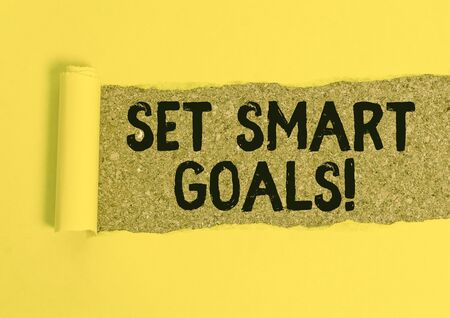 Word writing text Set Smart Goals. Business photo showcasing list to clarify your ideas focus efforts use time wisely Cardboard which is torn in the middle placed above a wooden classic tableの写真素材