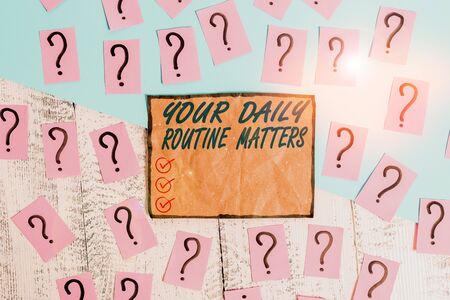 Writing note showing Your Daily Routine Matters. Business concept for practice of regularly doing things in fixed order Scribbled and crumbling papers with thick cardboard above wooden tableの写真素材