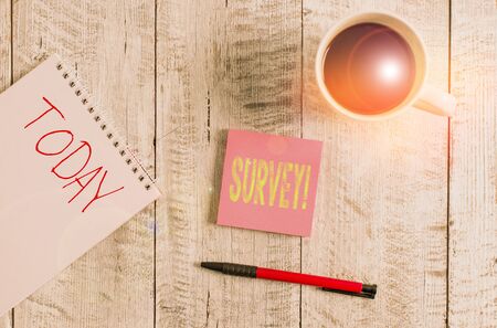 Writing note showing Survey. Business concept for research method used for collecting data from a predefined group Stationary placed next to a cup of black coffee above the wooden tableの写真素材