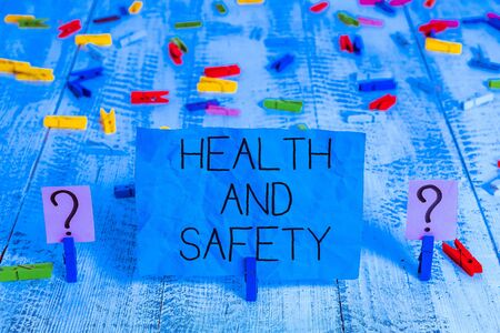 Handwriting text Health And Safety question. Conceptual photo regulations and procedures intended to prevent accident Scribbled and crumbling sheet with paper clips placed on the wooden tableの写真素材