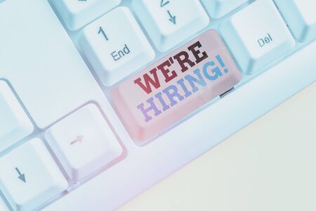 Text sign showing We Re Hiring. Business photo text process of reviewing applications and finding candidates White pc keyboard with empty note paper above white background key copy spaceの写真素材