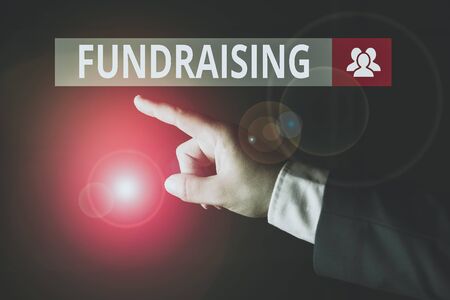 Conceptual hand writing showing Fundraising. Concept meaning seeking to generate financial support for charity or cause Isolated hand pointing with finger. Business conceptの写真素材