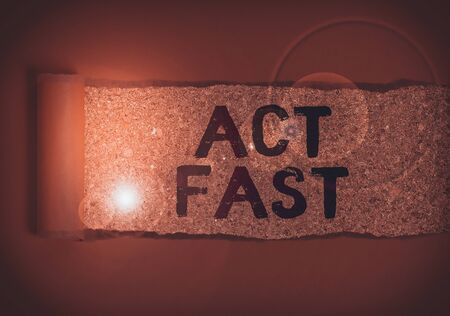Text sign showing Act Fast. Business photo text Voluntarily move in the highest state of speed initiatively Cardboard which is torn in the middle placed above a wooden classic tableの写真素材