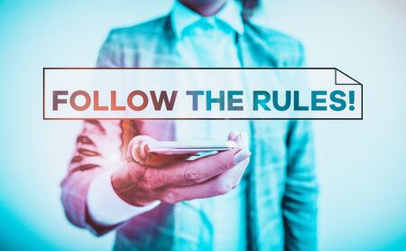Handwriting text Follow The Rules. Conceptual photo go with regulations governing conduct or procedure Business concept with mobile phone and business womanの写真素材