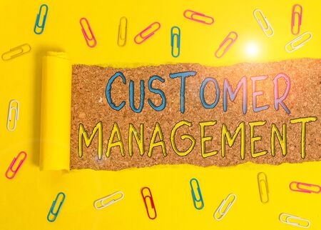 Text sign showing Customer Management. Business photo text customer retention and ultimately driving sales growth Paper clip and torn cardboard placed above a wooden classic table backdropの写真素材