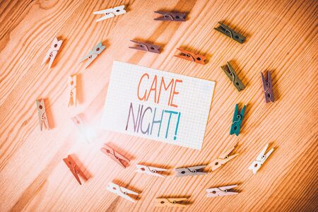Text sign showing Game Night. Business photo text usually its called on adult play dates like poker with friends Colored clothespin papers empty reminder wooden floor background officeの写真素材