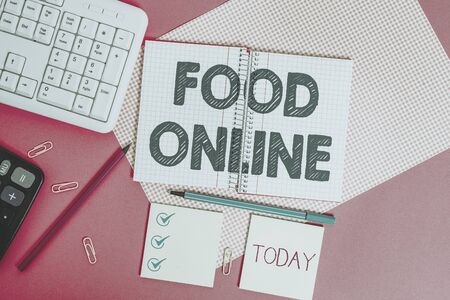 Word writing text Food Online. Business photo showcasing most convenient way for customers to purchase food online Writing equipments and computer stuffs placed above colored plain tableの写真素材