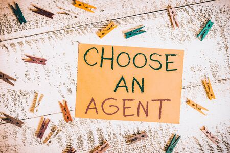 Conceptual hand writing showing Choose An Agent. Concept meaning Choose someone who chooses decisions on behalf of you Colored clothespin rectangle shaped paper blue backgroundの写真素材