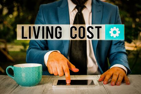 Word writing text Living Cost. Business photo showcasing the amount of money that a demonstrating needs to sustain life Businessman with pointing finger in front of himの写真素材