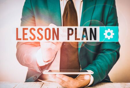 Writing note showing Lesson Plan. Business concept for a teacher s is detailed description of the course of instruction Businessman pointing with pen in empty copy spaceの写真素材