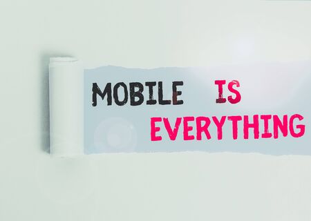 Text sign showing Mobile Is Everything. Business photo text Handheld Computer Device a Planner Wallet Organizer Cardboard which is torn in the middle placed above a plain table backdropの写真素材