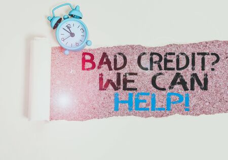 Handwriting text writing Bad Credit Question We Can Help. Conceptual photo offering help after going for loan then rejected Alarm clock and torn cardboard placed above a wooden classic table backdropの写真素材