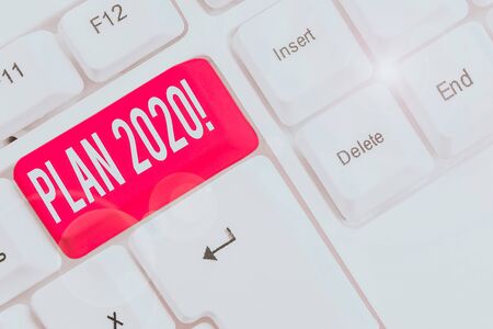 Writing note showing Plan 2020. Business concept for detailed proposal doing achieving something next year White pc keyboard with note paper above the white backgroundの写真素材