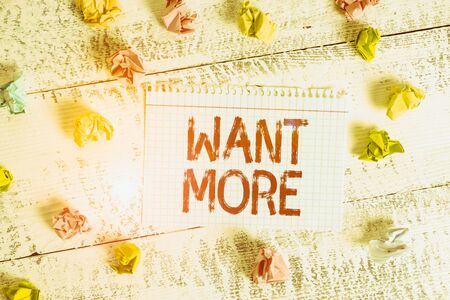 Handwriting text writing Want More. Conceptual photo Not having enough of something bigger challenges requirements Crumpled colored rectangle square shaped paper reminder white wood deskの写真素材