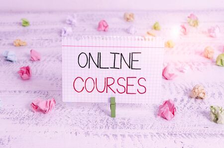 Writing note showing Online Courses. Business concept for courses deliver a series of lessons to a web browser Green clothespin white wood background reminder office supplyの写真素材