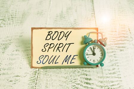 Writing note showing Body Spirit Soul Me. Business concept for Personal Balance Therapy Conciousness state of mind Alarm clock tilted above buffer wire in front of notepaperの写真素材