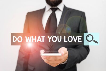 Writing note showing Do What You Love. Business concept for Make enjoyable things do activities with motivation Male human wear formal work suit hold smartphone using handの写真素材