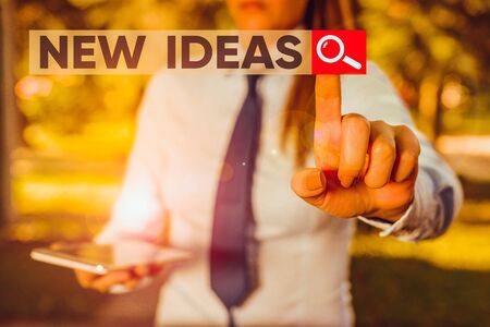 Word writing text New Ideas. Business photo showcasing something original or fresh and more effective innovation Handsome business girl pointing with finger into empty spaceの写真素材