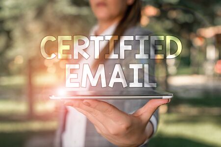 Conceptual hand writing showing Certified Email. Concept meaning email whose sending is certified by a neutral thirdparty Outdoor scene with business woman holds lap top with touch screenの写真素材