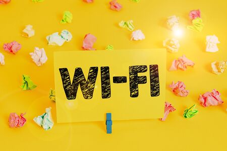 Text sign showing Wi Fi. Business photo text radio technologies commonly used for wireless local area networking Colored crumpled papers empty reminder white floor background clothespinの写真素材