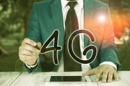 Handwriting text writing 4G. Conceptual photo Mobile communication standard Wireless internet access at a higher speed Businessman holds pen and points into copy spaceの写真素材