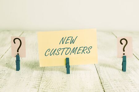 Conceptual hand writing showing New Customers. Concept meaning an entity that has not previously purchased one goods Crumbling sheet with paper clips placed on the wooden tableの写真素材