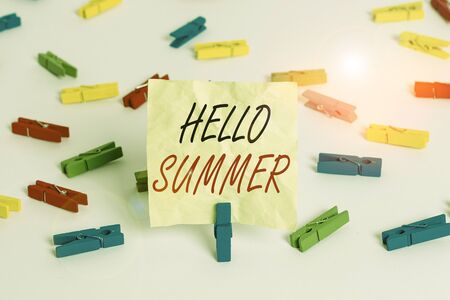 Writing note showing Hello Summer. Business concept for season after spring and before autumn where the weather is hot Colored clothespin papers empty reminder white floor background officeの写真素材