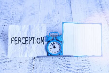 Conceptual hand writing showing Perception. Concept meaning individuals organize and interpret their sensory impressions Alarm clock tilted above buffer wire in front of notepaperの写真素材