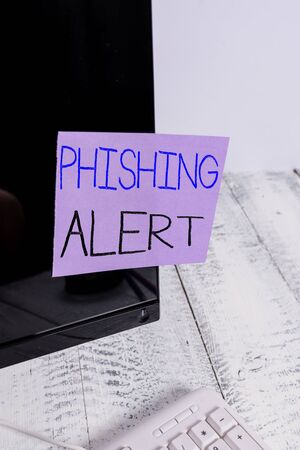 Text sign showing Phishing Alert. Business photo showcasing aware to fraudulent attempt to obtain sensitive information Notation paper taped to black computer monitor screen near white keyboardの写真素材