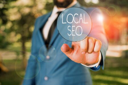 Word writing text Local Seo. Business photo showcasing helps businesses promote products and services to local customers Businessman with pointing finger in front of himの写真素材