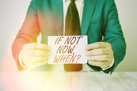 Conceptual hand writing showing If Not Now When Question. Concept meaning start acting from this moment do not hesitate Man holds empty paper with copy space in front of him Spaceの写真素材