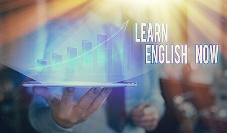 Writing note showing Learn English Now. Business concept for gain or acquire knowledge and skill of english languageの写真素材