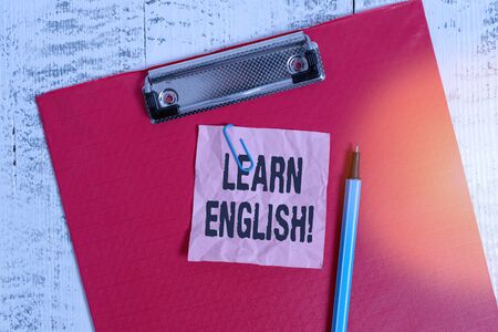 Conceptual hand writing showing Learn English. Concept meaning gain acquire knowledge in new language by study Colored clipboard crushed sticky note marker old wooden backgroundの写真素材