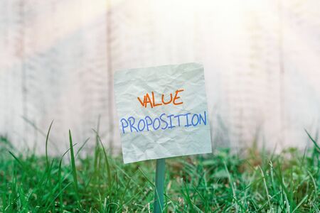Handwriting text Value Proposition. Conceptual photo feature intended to make a company or product attractive Plain empty paper attached to a stick and placed in the green grassy landの写真素材