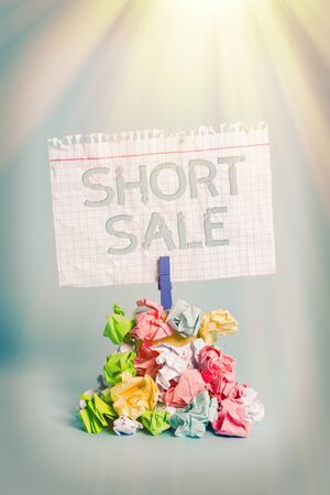 Word writing text Short Sale. Business photo showcasing Home that is offered at a price that is less than the amount owed Reminder pile colored crumpled paper clothespin reminder blue backgroundの写真素材