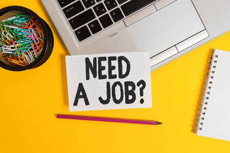Writing note showing Need A Job Question. Business concept for to recruit a demonstrating for specific duty role or function Laptop pencil squared paper sheet container spiral colored backgroundの写真素材