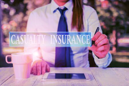 Conceptual hand writing showing Casualty Insurance. Concept meaning overage against loss of property or other liabilities Female business person sitting and holding mobile phoneの写真素材