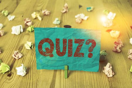 Word writing text Quiz Question. Business photo showcasing test of knowledge as competition between individuals or teams Colored crumpled papers empty reminder wooden floor background clothespinの写真素材