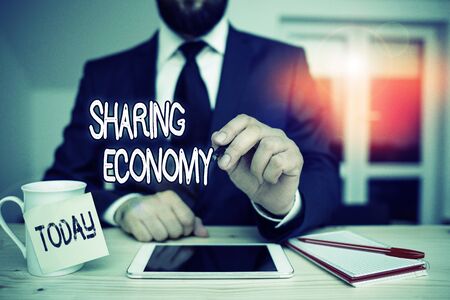 Word writing text Sharing Economy. Business photo showcasing collaborative consumption or peer to peer based sharing Male human wear formal clothes present presentation use hi tech smartphoneの写真素材