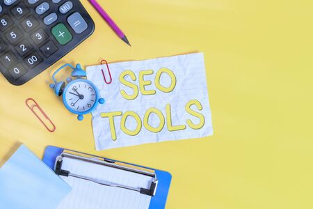 Writing note showing Seo Tools. Business concept for process of affecting online visibility of website or page Alarm clock crushed note calculator pencil clipboard color backgroundの写真素材